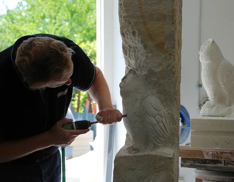 Bildhauer bei der Arbeit an einer Eulenfigur